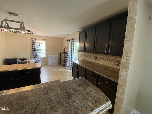 401 Lawton Dr, Haw River, NC 27258 - kitchen with tasteful backsplash, baseboards, dark cabinetry, decorative light fixtures, and stone countertops