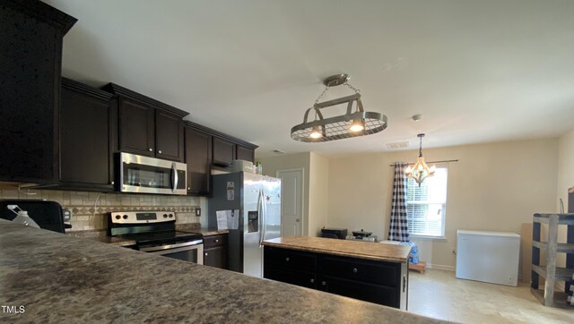 401 Lawton Dr, Haw River, NC 27258 - kitchen with appliances with stainless steel finishes, tasteful backsplash, baseboards, and dark cabinetry