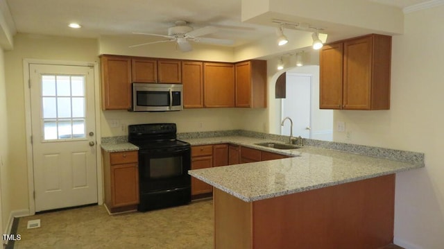 kitchen with sink, kitchen peninsula, light stone countertops, and black / electric stove