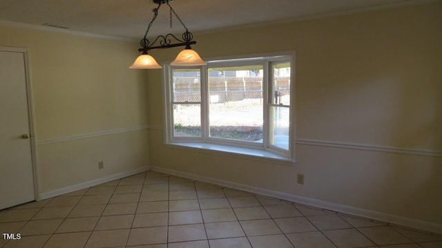 tiled spare room featuring crown molding