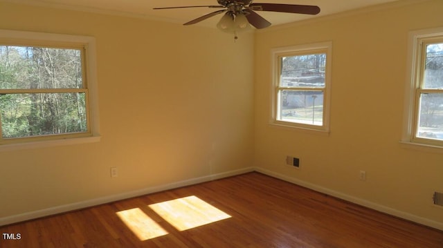 unfurnished room with ceiling fan, a wealth of natural light, and hardwood / wood-style flooring