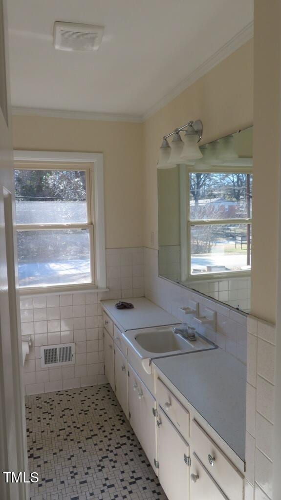 bathroom featuring tile patterned flooring, vanity, tile walls, and ornamental molding