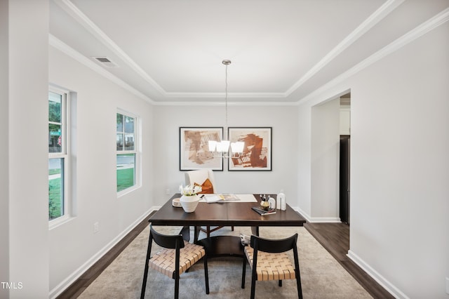 dining area featuring dark wood-type flooring, an inviting chandelier, and crown molding