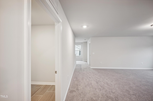 corridor featuring light colored carpet