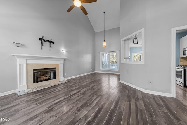 unfurnished living room with high vaulted ceiling, a tile fireplace, dark hardwood / wood-style flooring, and ceiling fan