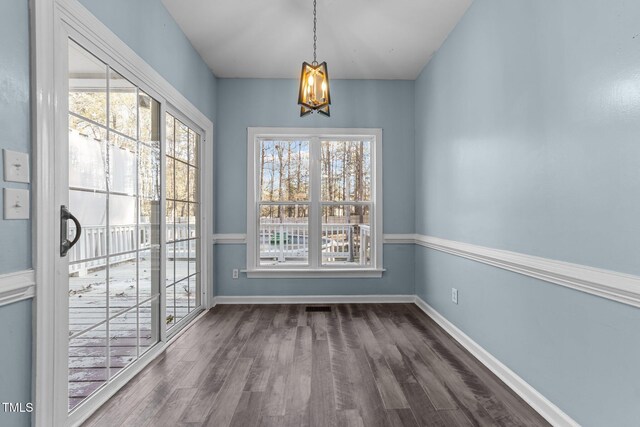 unfurnished dining area featuring dark hardwood / wood-style flooring