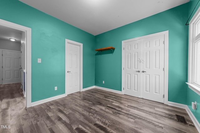 unfurnished bedroom with a closet and hardwood / wood-style floors