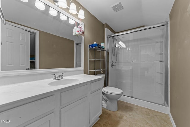 bathroom with a shower with shower door, vanity, tile patterned flooring, and toilet