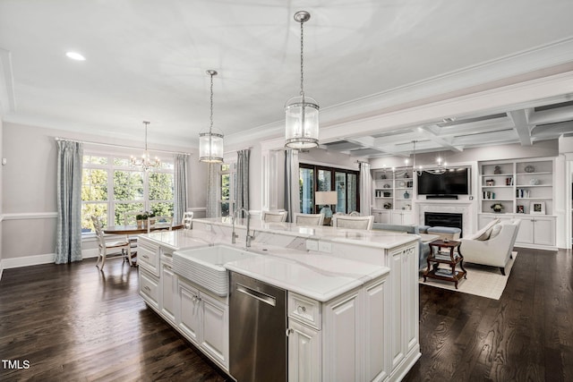 kitchen with decorative light fixtures, stainless steel dishwasher, sink, coffered ceiling, and an island with sink