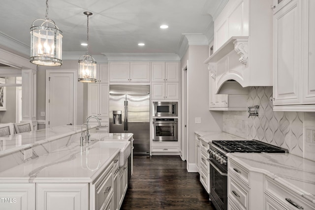 kitchen with decorative light fixtures, light stone countertops, white cabinetry, and built in appliances