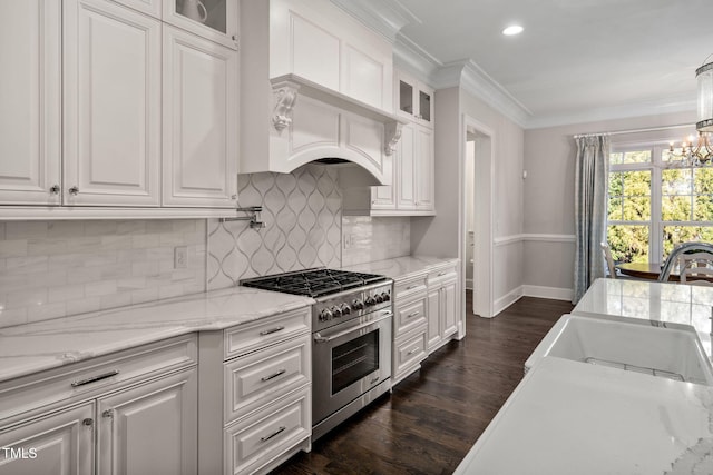 kitchen with high end stove, sink, crown molding, and white cabinetry