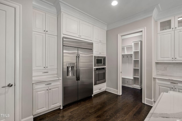 kitchen with dark hardwood / wood-style floors, light stone countertops, white cabinets, and built in appliances