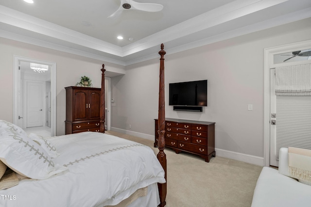 carpeted bedroom with a tray ceiling and ornamental molding