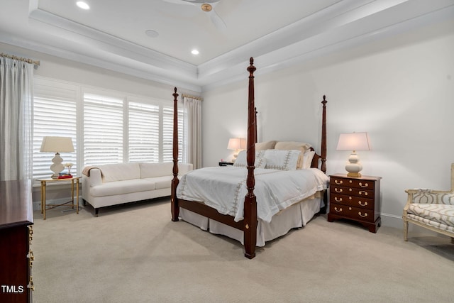 bedroom featuring ceiling fan, light colored carpet, a tray ceiling, and crown molding