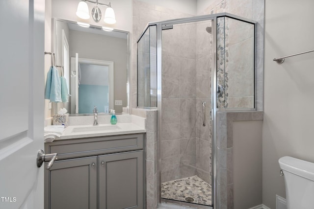 bathroom with an enclosed shower, vanity, and toilet