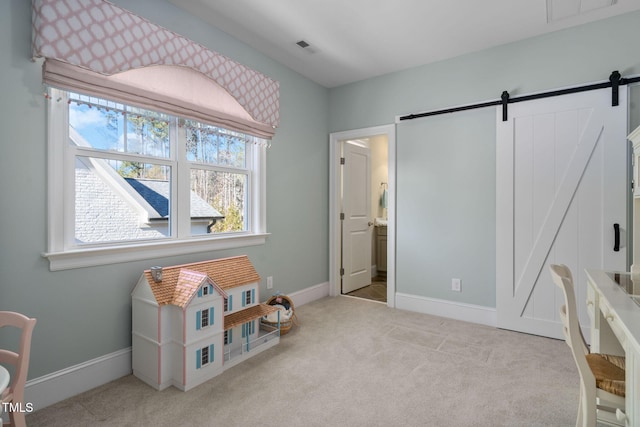 playroom featuring light carpet and a barn door