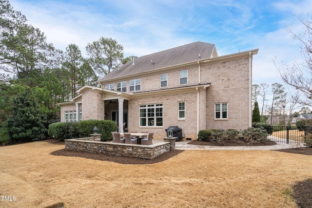 back of property with a yard and a patio