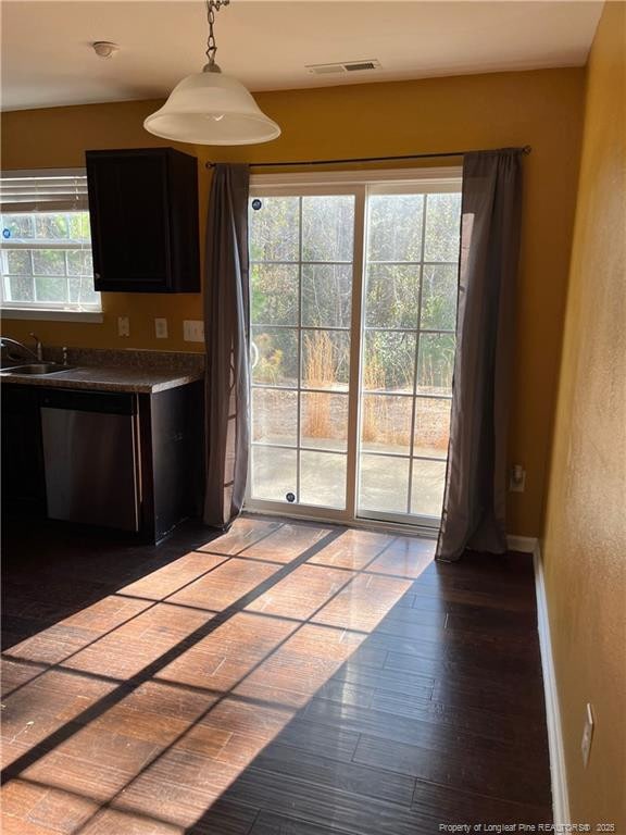 kitchen featuring decorative light fixtures, hardwood / wood-style flooring, dishwasher, and sink