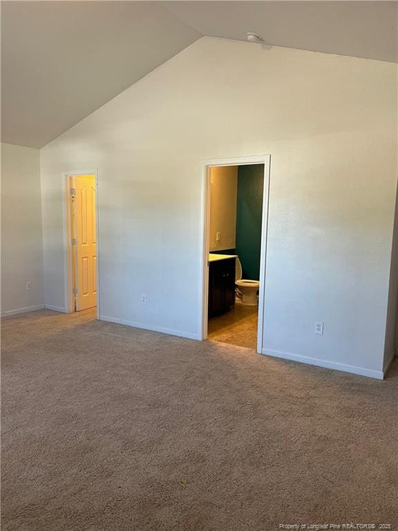 spare room featuring high vaulted ceiling and light colored carpet