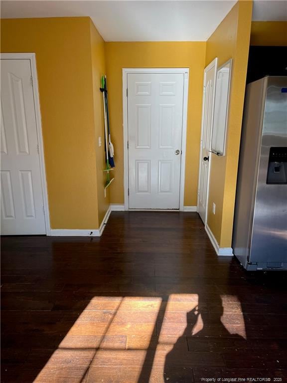 hallway with baseboards and wood finished floors