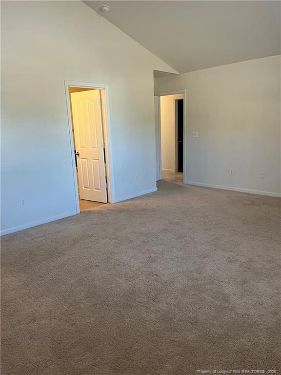 unfurnished room with high vaulted ceiling, baseboards, and light colored carpet