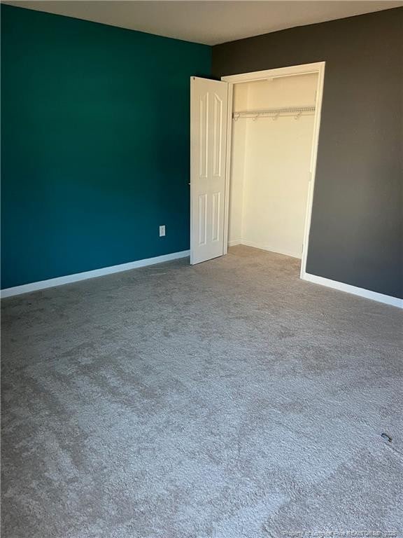 unfurnished bedroom featuring baseboards, a closet, and carpet flooring