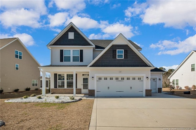 craftsman inspired home with covered porch, a front lawn, and a garage