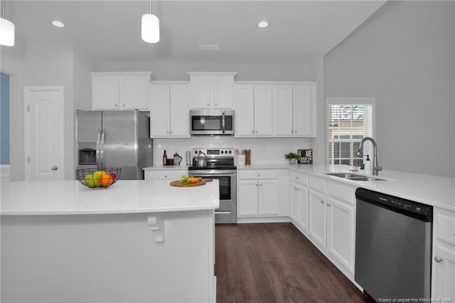 kitchen with stainless steel appliances, sink, decorative light fixtures, white cabinets, and backsplash