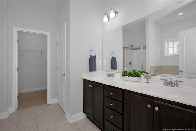 bathroom with tile patterned flooring, a shower with door, and vanity