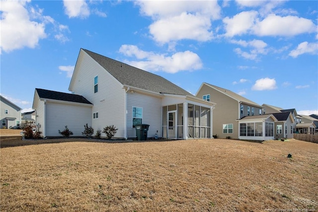 back of property featuring a lawn and a sunroom