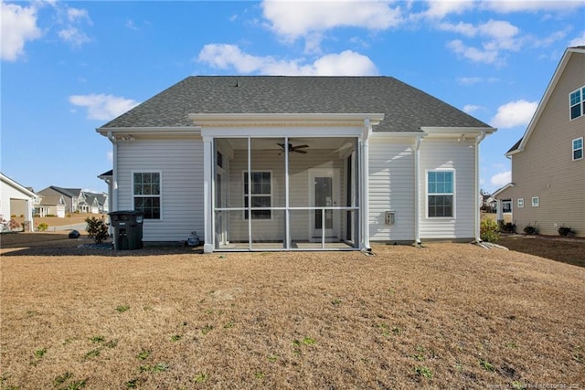 rear view of house with ceiling fan, a sunroom, and a lawn