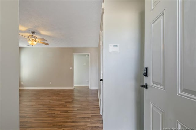 foyer with dark wood-type flooring, a textured ceiling, and ceiling fan