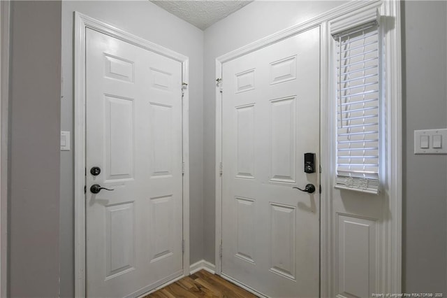 entryway with a textured ceiling and dark hardwood / wood-style floors