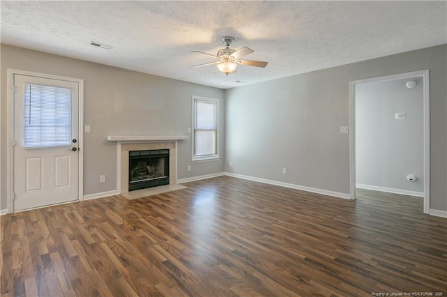 unfurnished living room with a textured ceiling, ceiling fan, and dark hardwood / wood-style floors