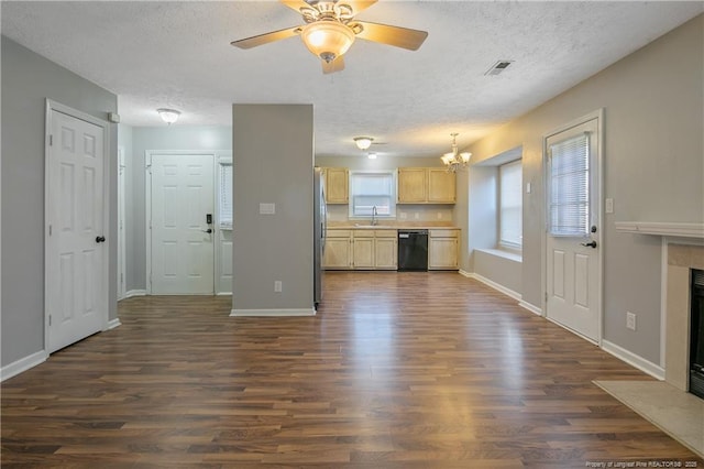 unfurnished living room featuring ceiling fan with notable chandelier, a textured ceiling, sink, and dark wood-type flooring