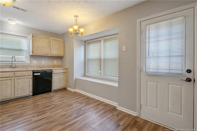 kitchen with sink, black dishwasher, light brown cabinets, and hanging light fixtures