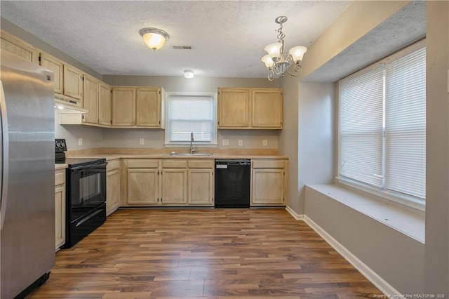 kitchen featuring sink, light brown cabinets, hanging light fixtures, dark hardwood / wood-style floors, and black appliances