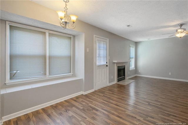 unfurnished living room featuring a textured ceiling, dark wood-type flooring, and ceiling fan with notable chandelier