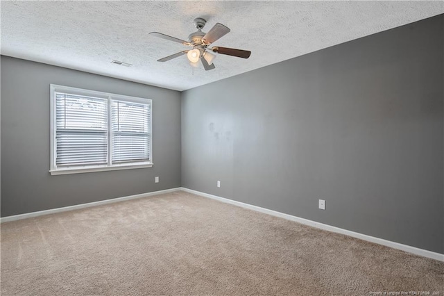 carpeted spare room with a textured ceiling and ceiling fan