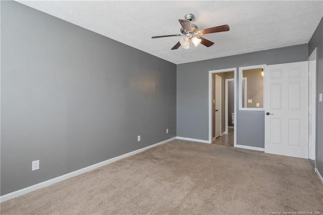 empty room with a textured ceiling, ceiling fan, and light colored carpet