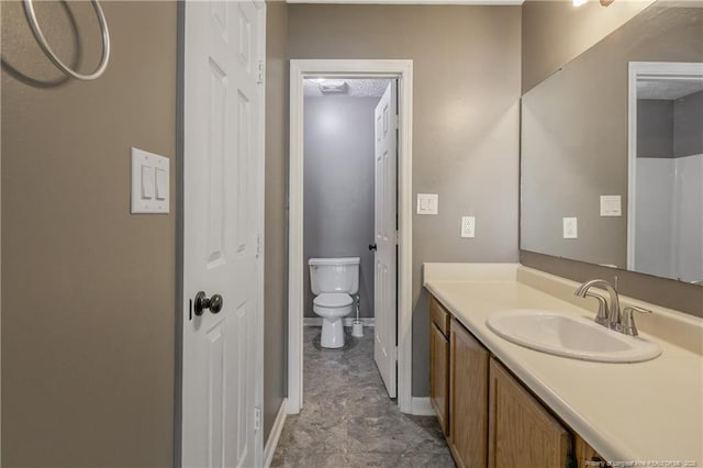 bathroom featuring a textured ceiling, vanity, and toilet