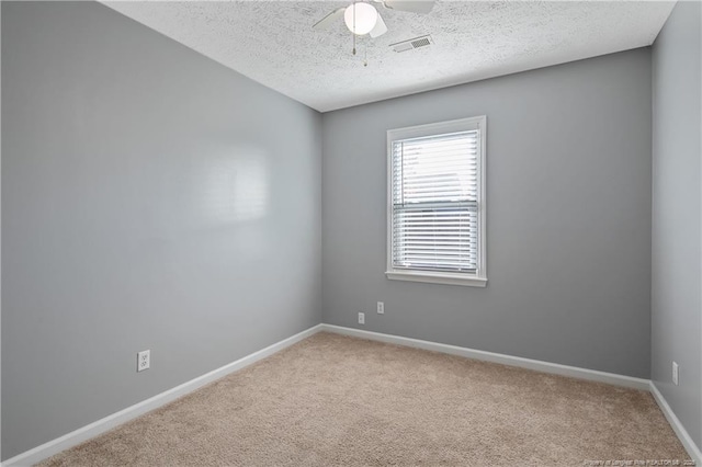 carpeted spare room featuring a textured ceiling and ceiling fan