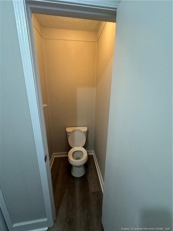 bathroom with toilet and hardwood / wood-style flooring