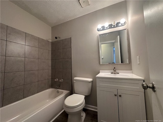 full bathroom with toilet, tiled shower / bath combo, a textured ceiling, and vanity