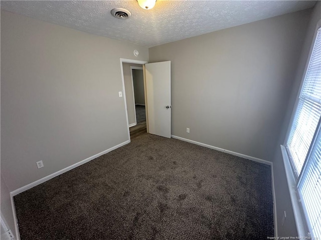 carpeted spare room featuring a textured ceiling