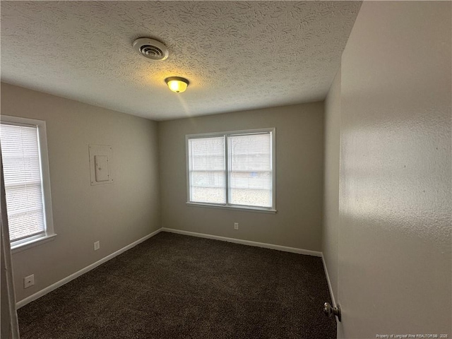 carpeted empty room featuring a textured ceiling