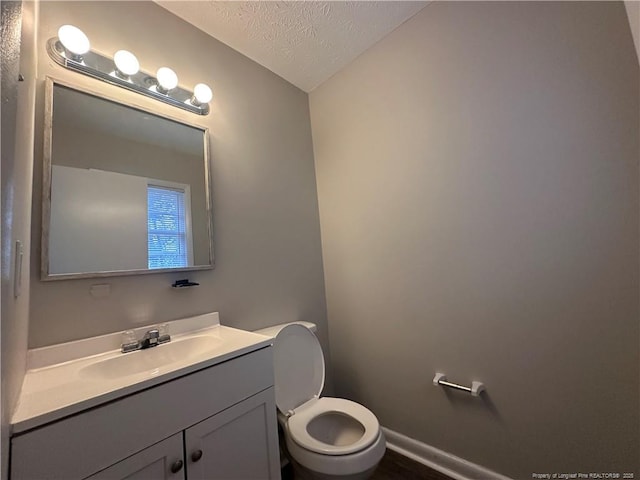 bathroom featuring a textured ceiling, vanity, and toilet