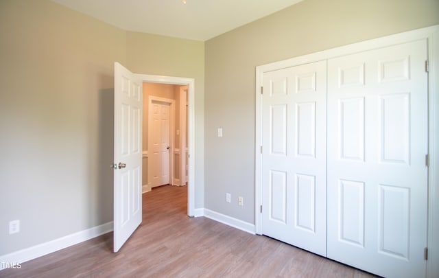 unfurnished bedroom featuring a closet and light wood-type flooring