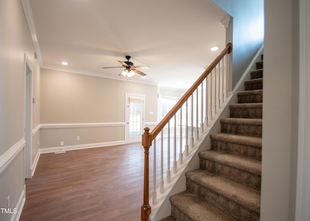 staircase featuring ornamental molding, ceiling fan, and hardwood / wood-style floors