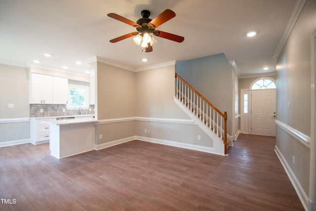 kitchen with white cabinets, hardwood / wood-style floors, crown molding, and kitchen peninsula